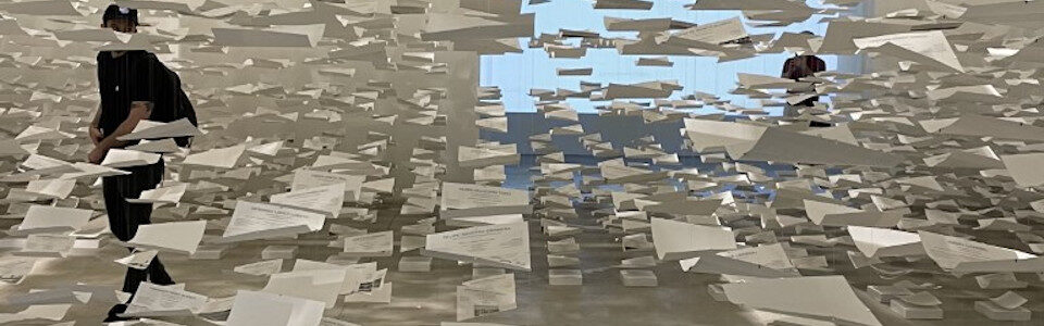 Installazione con persona in mezzo a fogli di carta